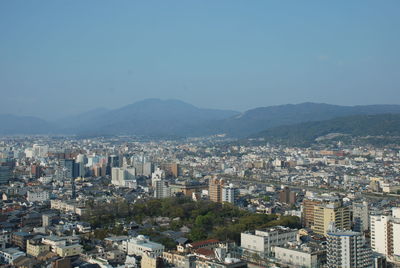 Aerial view of buildings in city against clear sky