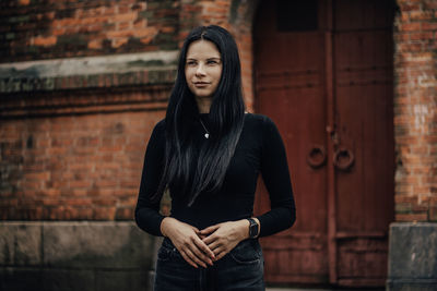 Young woman standing against wall