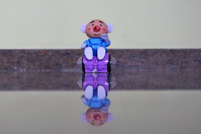 Close-up of toy figurine on table against wall