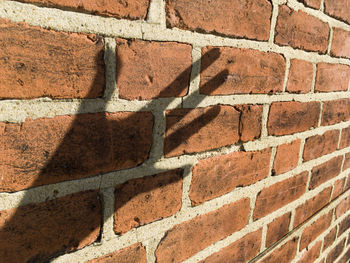 Shadow of hand on brick wall