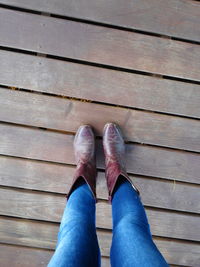 Low section of a woman standing on wooden floor