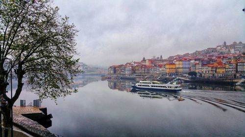 Panoramic view of boats moored in water against sky