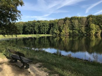 Scenic view of lake by trees against sky