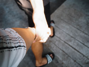 Low section of couple walking on floorboard