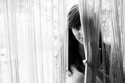 Close-up of young woman looking through window