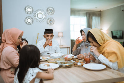 Rear view of people sitting on table