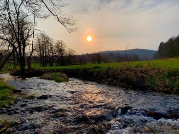 Scenic view of river stream against sky during sunset