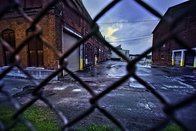 Surface level of chainlink fence against buildings in city