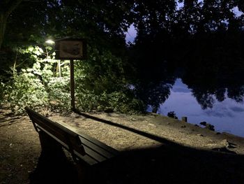 Empty park by lake against sky at night