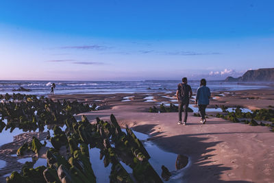 People on beach against sky