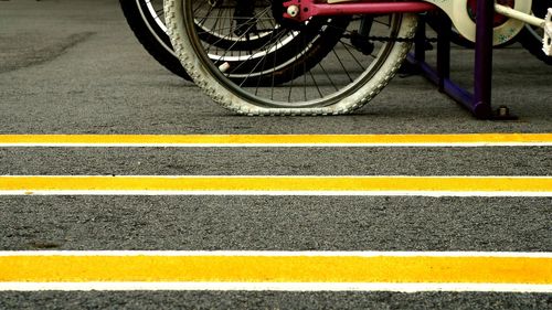 Bicycle parked in rack with flat tire at parking lot