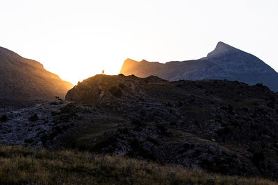 Peaks of breathtaking mountain ridge located against bright sunrise sky in morning in pyrenees