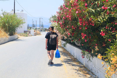 Rear view of man walking on footpath