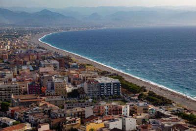 High angle view of townscape by sea against sky