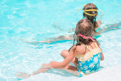 Rear view of woman swimming in pool
