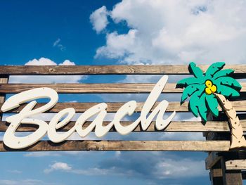 Wooden sign with the word beach with blue sky in the background