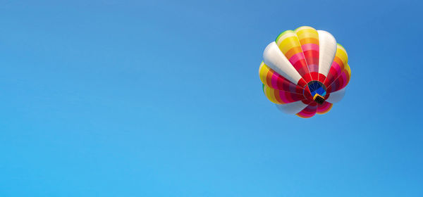 Low angle view of hot air balloon against blue sky