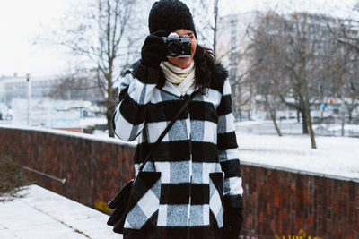 Woman standing on snow covered landscape