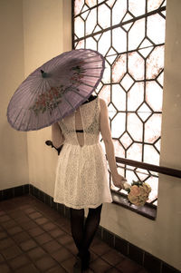 Woman with umbrella standing on floor