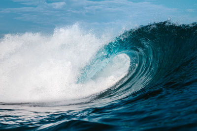 Blue wave breaking on a beach in indonesia