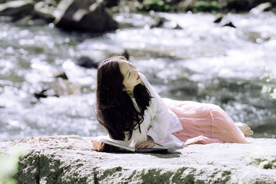 Young woman sitting on rock