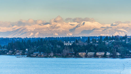 A view of the shoreline of bellevue, washington with mountains in the distance.