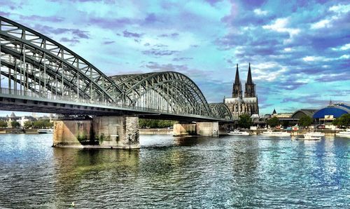 Bridge over river against cloudy sky