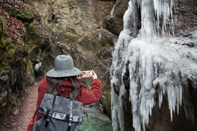 Woman taking a photo in a rocky gorge.