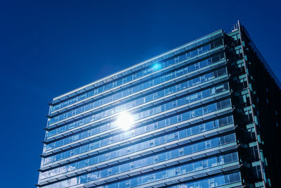 Low angle view of modern building against blue sky
