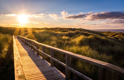 Empty wooden footbridge during sunset