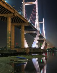 Low angle view of bridge over river at night