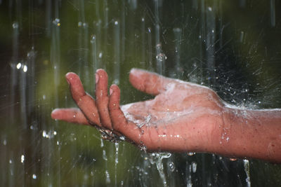 Close-up of hand touching water splashing