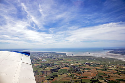 Airplane flying over landscape against sky