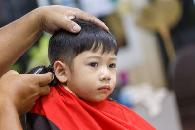 Cropped hands cutting boy hair