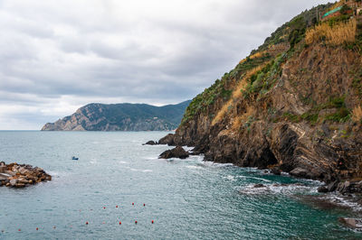 Scenic view of sea and mountains against sky