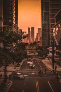 City street and buildings against sky during sunset