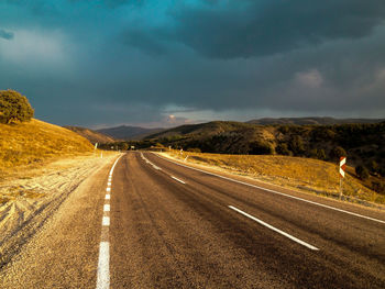 Road passing through landscape against sky