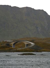 Arch bridge over river against mountains