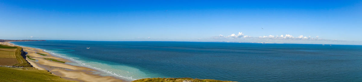 Panoramic view of sea against blue sky