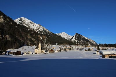 Scenic view of snowcapped mountains against clear blue sky