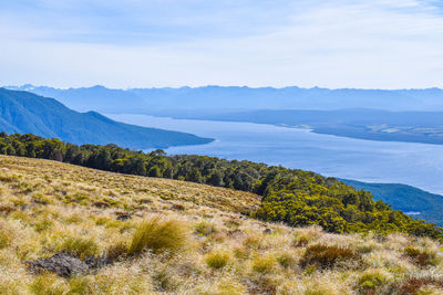 Scenic view of sea and mountains against sky