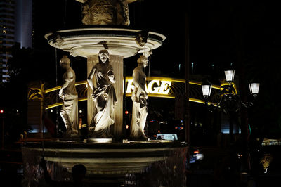 Close-up of statue against illuminated building at night