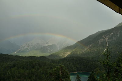 Scenic view of rainbow over mountains against sky