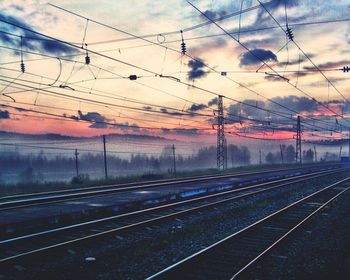 Train on railroad tracks against cloudy sky