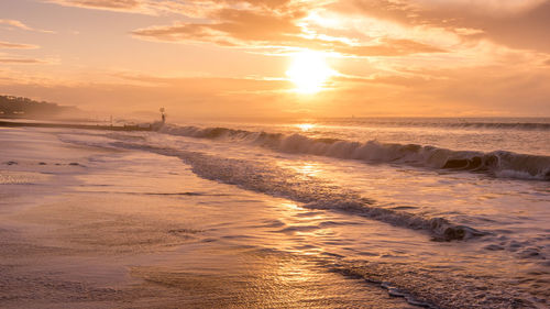 Scenic view of beach against sky during sunset