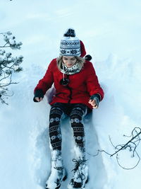 Full length portrait of girl playing on snow covered field