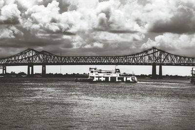 Bridge over river against cloudy sky