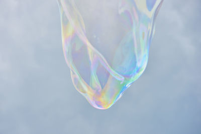 Low angle view of bubble against cloudy sky