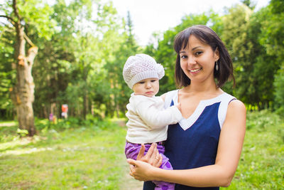 Portrait of a smiling young woman against plants