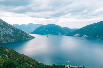 Scenic view of lake by mountains against sky